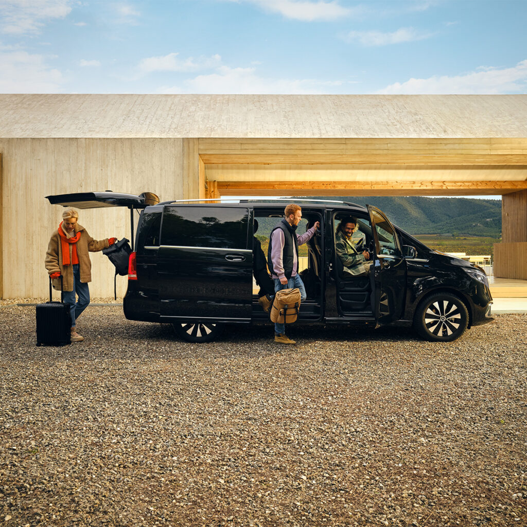 Eine Familie steigt aus einem Mercedes-Benz Transporter vor einem modernen Haus aus, repräsentiert flexible Mietmöglichkeiten für Familienreisen.