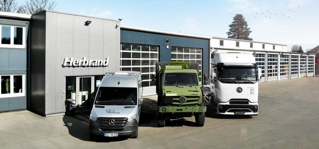 Mercedes-Benz Transporter, UNIMOG und Lkw vor der Herbrand Werkstatt in Wesel.