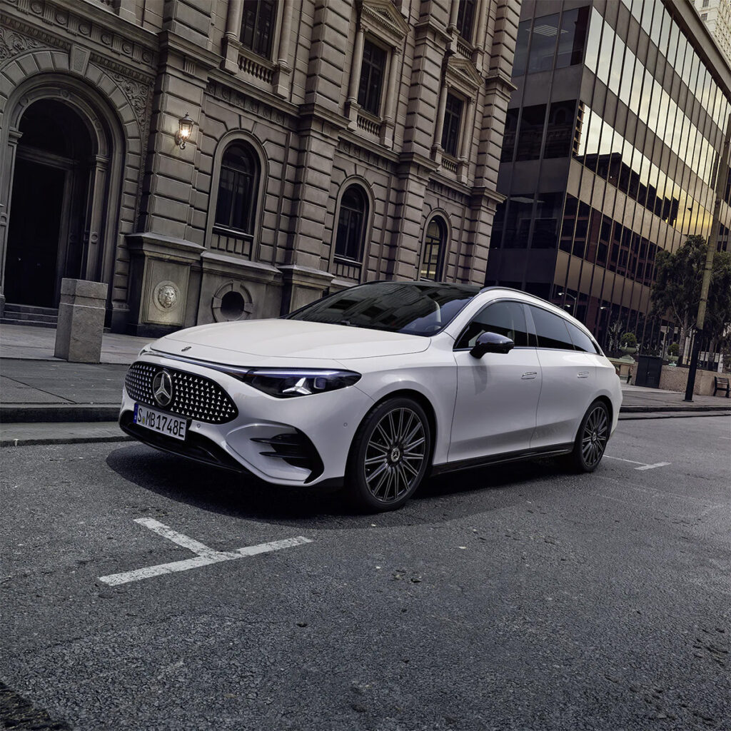 Weißer Mercedes-Benz CLA Shooting Brake vor einem Gebäude auf einer Straße.