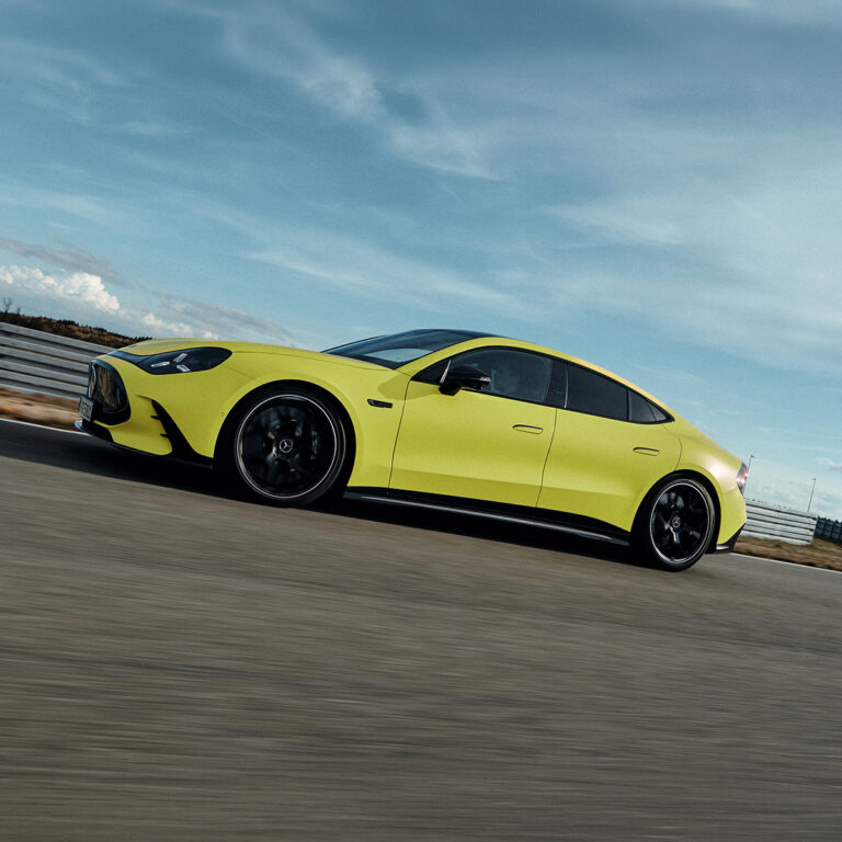 Seitliche Ansicht des neuen Mercedes-AMG GT 4-Türer Coupé in Gelb auf einer Rennstrecke mit Herbrand Kennzeichen