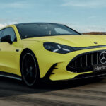 Das neue Mercedes-AMG GT 4-Türer Coupé in Gelb auf einer Rennstrecke mit Herbrand Kennzeichen